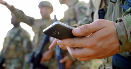Mid section of caucasian military soldier using mobile phone during military training 4k
