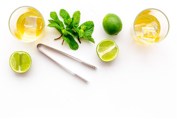 Alcoholic beverage. Whiskey with ice, mint and lime on white background top view copy space