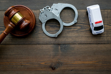 Crime concept. Police car toy, handcuff, judge hammer on dark wooden background top view space for...