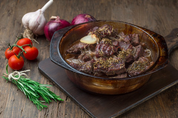 Goulash, beef stew in glass  baking dish on dark background,
