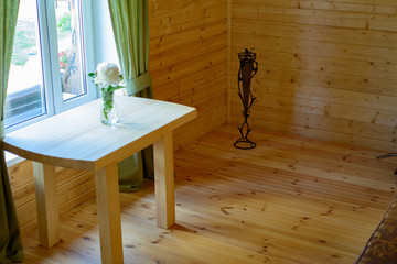 a vase with a flower peony stands on a table by the window