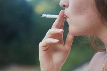 Obraz premium Young girl Smoking a cigarette. Close up. Lifestyle