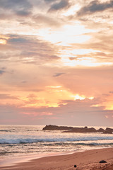 Stunning sunset on the beach overlooking the ocean and the waves. 