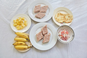 National cuisine of Sri Lanka. Rice cooked in coconut milk. Bananas. Sliced pineapple. Omelet. Tomato and onion salad.