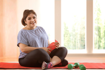 Overweight woman taking a break from exercising	