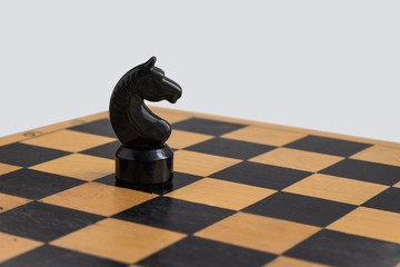 wooden chess knight is standing on Board © Irina