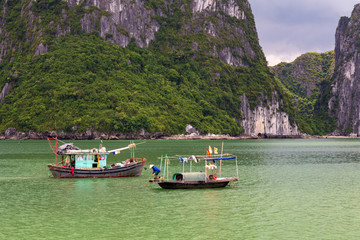 Halong bay with two Vietnamese traditional fishing boats, UNESCO world natural heritage, Vietnam.