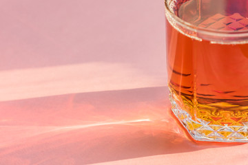 glass of apple juice on pink background. Non alcoholic beverage.