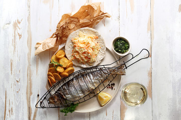 Pstrąg grillowany. Pieczona ryba podana z surówką i opiekanymi ziemniakami. © foodandcook
