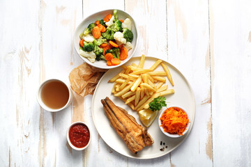 Smażony sum z frytkami, surówką i warzywami z wody. © foodandcook