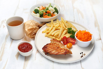 Grillowana pierś z kurczaka  z frytkami, surówką z marchewki i gotowanymi warzywami. © foodandcook