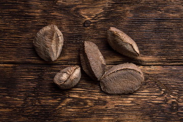 Brazil nuts on a brown wooden board background.