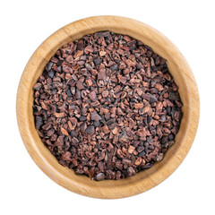 Cacao nibs. Crushed cocoa beans in wooden bowl isolated on white. Top view.