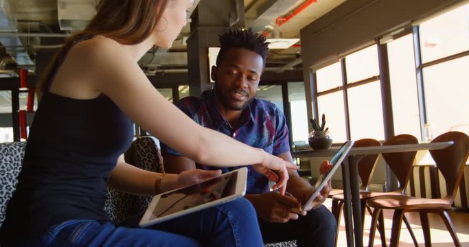 Side view of young cool mixed-race business team planning and sitting on couch of modern office 4k