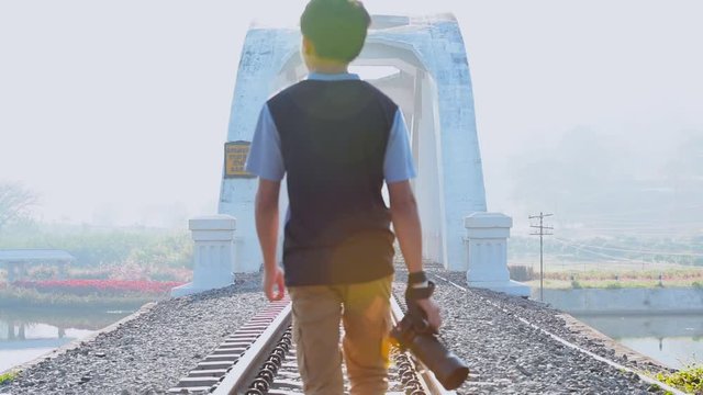 Photographer walking on the railway bridge