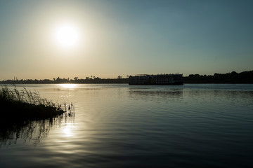 Large egyptian river cruise boat sailing on Nile at sunset