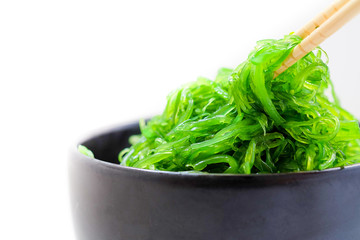 Hiyashi Wakame Chuka or seaweed salad in black bowl on white background ,Japanese food