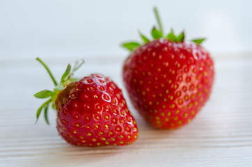 two strawberries on a wooden table
