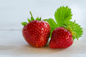two strawberries on a wooden table