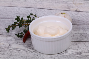 Mayonnaise sauce in the white bowl served thyme and garlic