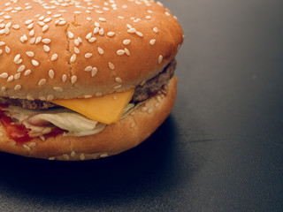 fast food. tasty hamburger on a dark background.