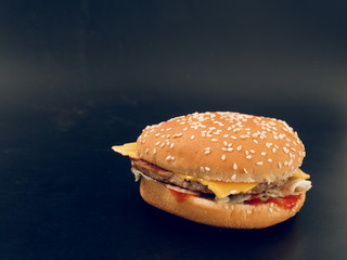 fast food. tasty hamburger on a dark background.