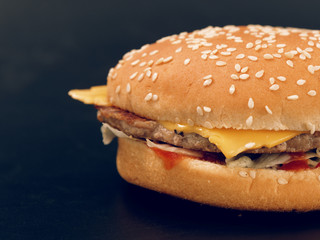 fast food. tasty hamburger on a dark background.
