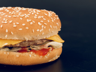 fast food. tasty hamburger on a dark background.