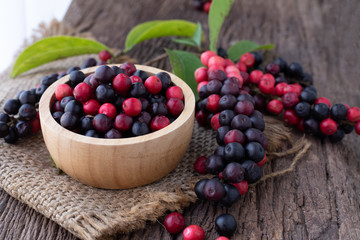wood kitchen table with thai blueberries, traditional thai fruit.