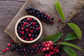 wood kitchen table with thai blueberries, traditional thai fruit.