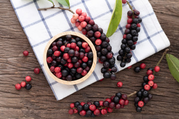 wood kitchen table with thai blueberries, traditional thai fruit.