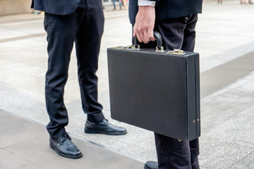 Businessman carrying briefcase and negotiations with partnership
