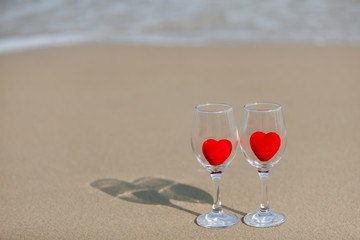 two glasses of red heart wine on a background