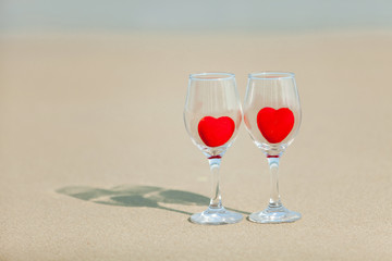 two glasses of red heart wine on a background