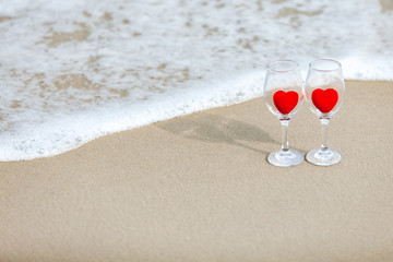 glass of champagne and rose heart on the beach