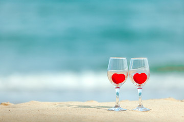 glass of red heart wine on the beach