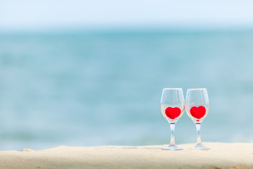 glass of red heart wine on the beach 