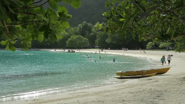 outrigger canoe on tropical beach with tourists, Champagne bay, Vanuatu