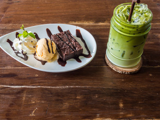 Ice cream with dessert and ice green milk tea on wood table