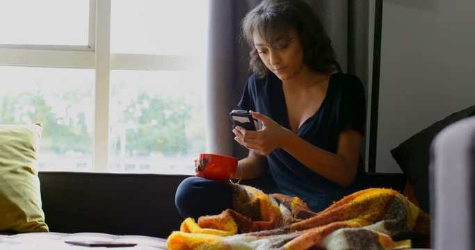 Front view of young asian woman using mobile pone at home 4k