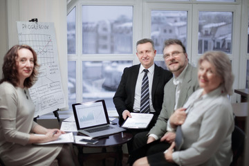 portrait of group of business people sitting near the desktop