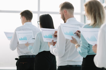 close up. employees with financial reports, standing in line.
