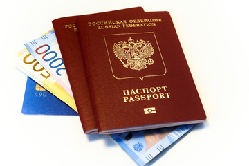 Russian passports are on banknotes and a bank card. Credit cards, money and Russian passports for travel. White isolated background.