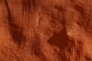 Naklejka premium close-up: plastered, rough orange wall, illuminated by bright side lights. With scratches, deep shadows and contrast 3