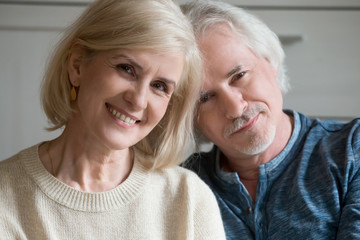 Close up portrait of aged couple smiling looking at camera