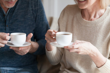Cropped image senior spouses holding cups with tea