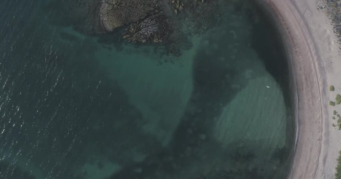 Sand, rock, and sea patterns on cristal clear waters.