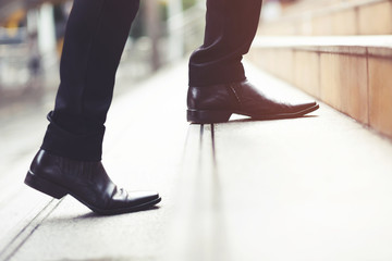modern businessman working  close-up legs walking up the stairs in modern city. in rush hour to...