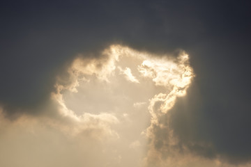 Golden sunlight ray shining throught dark clouds