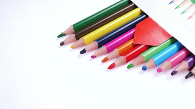Multicolored colorful children's pencils in the package rotate on a white background.